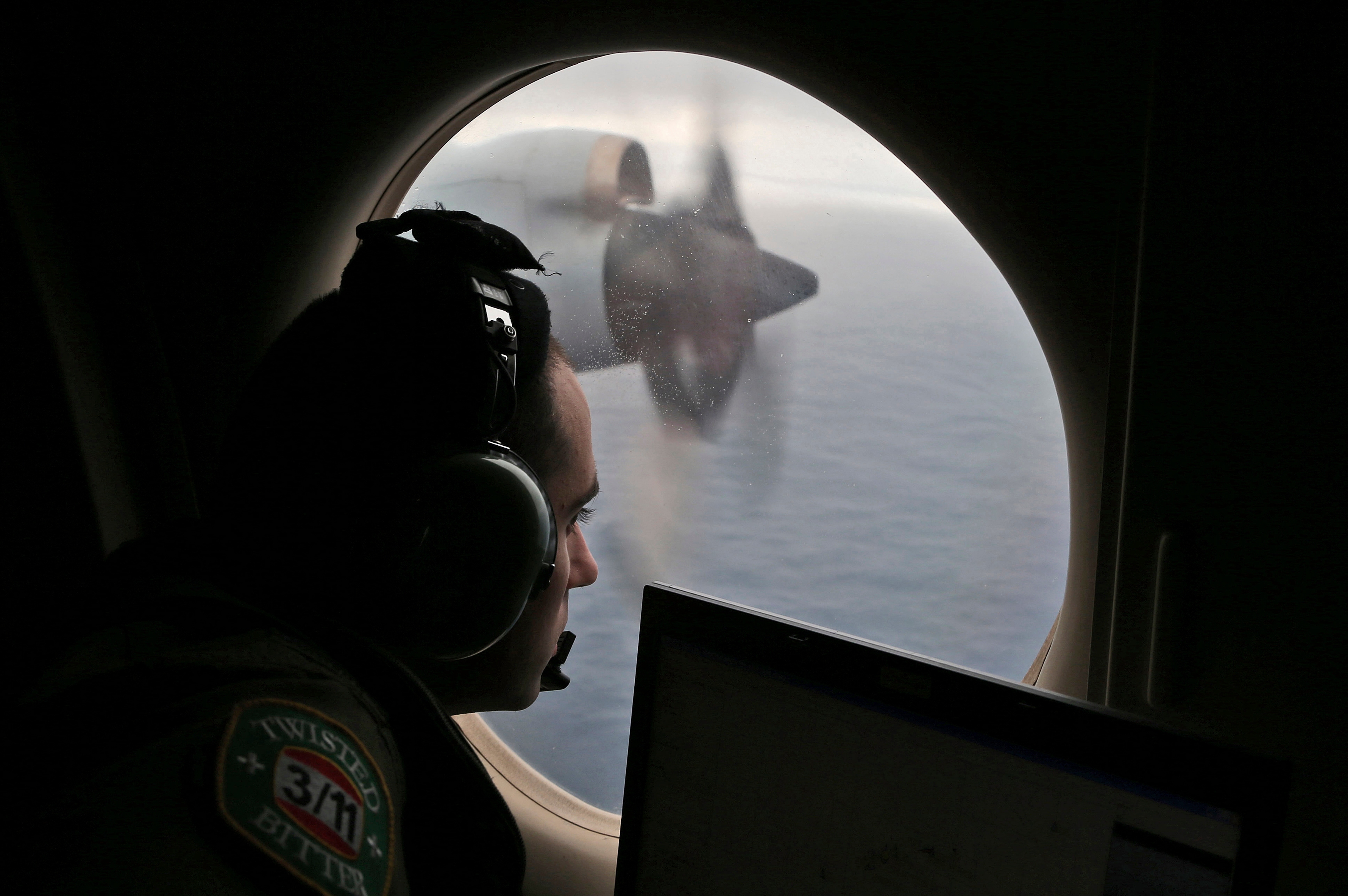 FILE - Flight officer Rayan Gharazeddine scans the water in the southern Indian Ocean off Australia from a Royal Australian Air Force AP-3C Orion during a search for the missing Malaysia Airlines Flight MH370 on March 22, 2014.